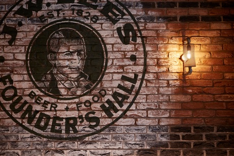 Image showing the Founder's Hall logo on an interior brick wall.