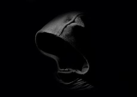 dark image of hooded figure with face in shadow.