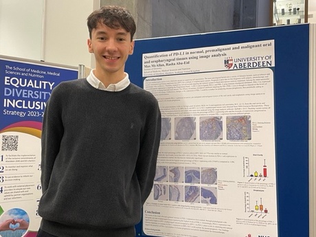 Max Mcallan standing in front of his poster