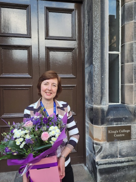 Photograph of Prof Irene Couzigou with complementary flowers from the Head of School for the organisation of a successful conference