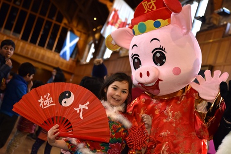A child and a pig mascot in Elphinstone Hall