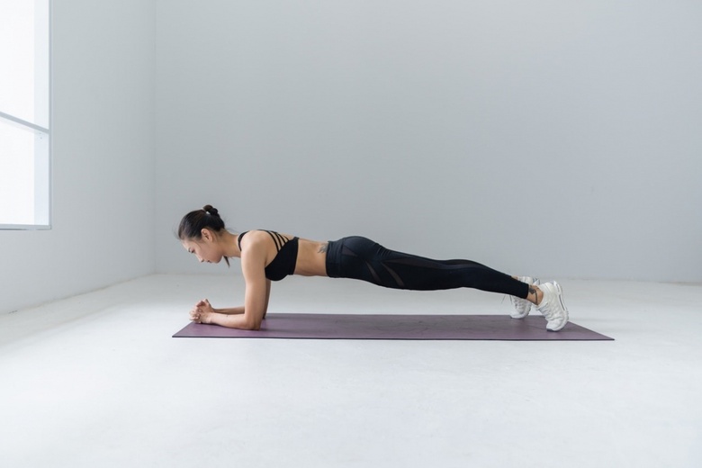 woman does a plank on a yoga mat
