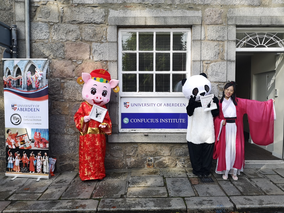 People dressed in Chinese-themed costumes in front of Confucius Institute