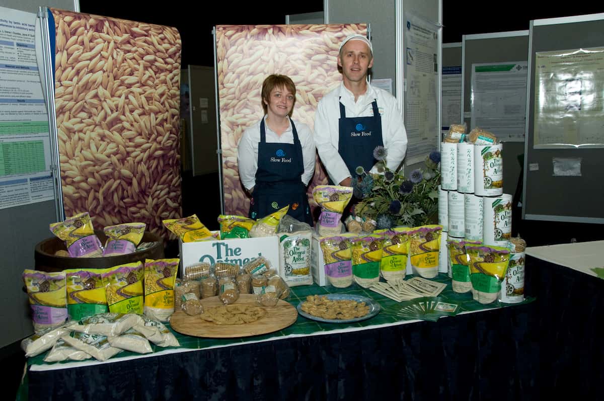 two people at stall selling produce