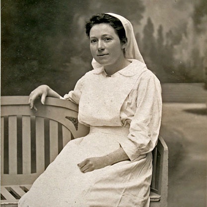 Amelia Nyasa Laws sitting on a bench in a nurses uniform, sepia toned.