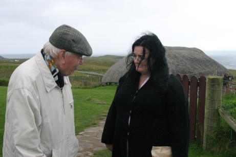 Man and woman talking in front of Highland black house