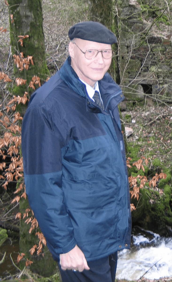 Stanley Robertson standing in front of burn