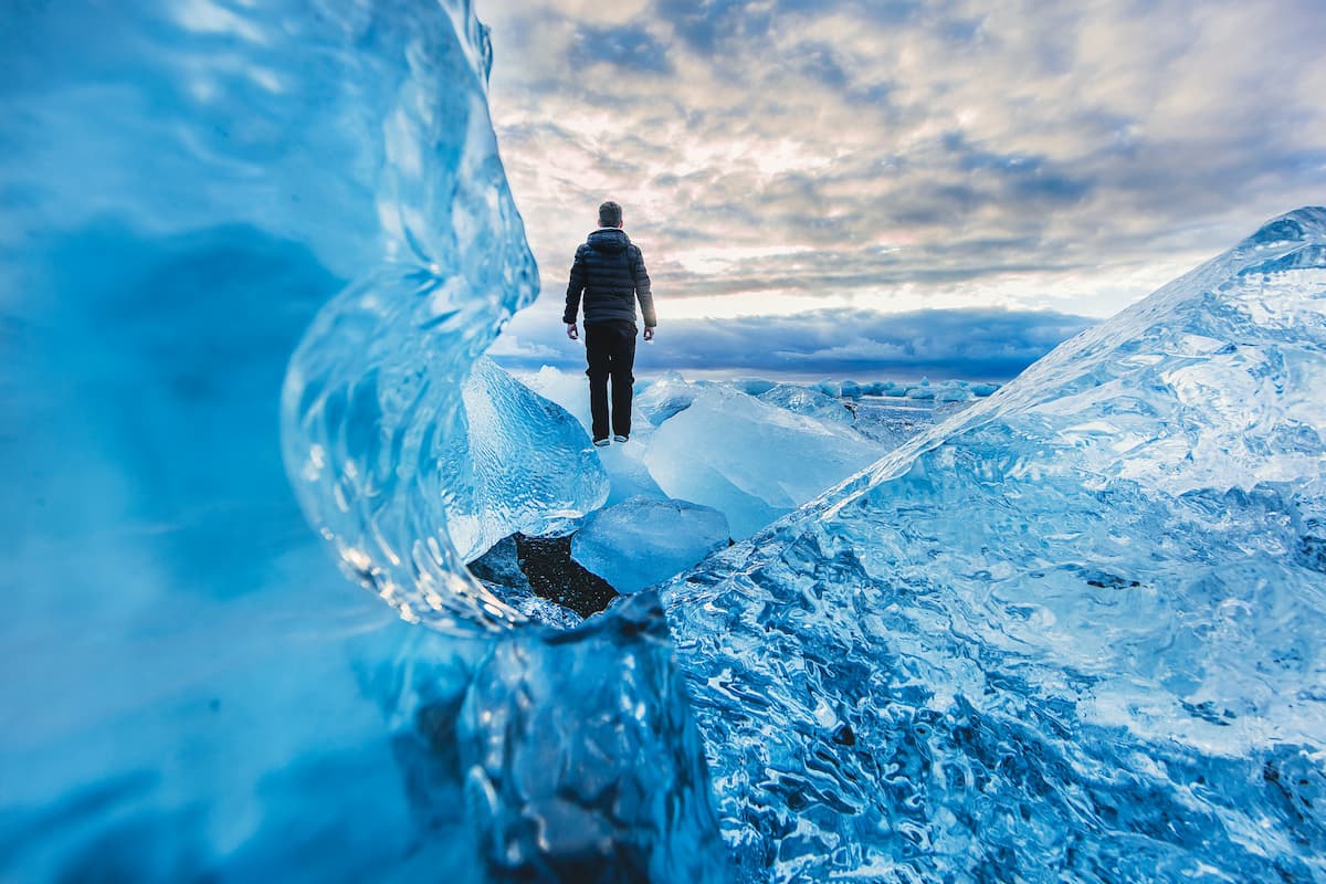 man walking on glacier