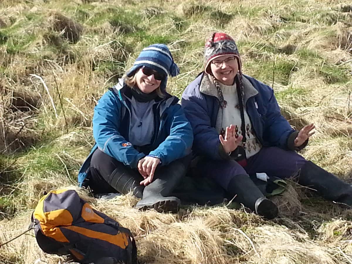 2 women sitting smiling on grass
