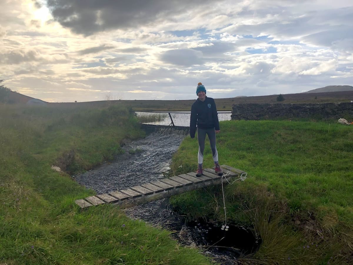 someone standing on rickety wooden bridge