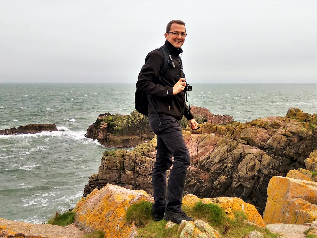 man standing on rocks by the sea