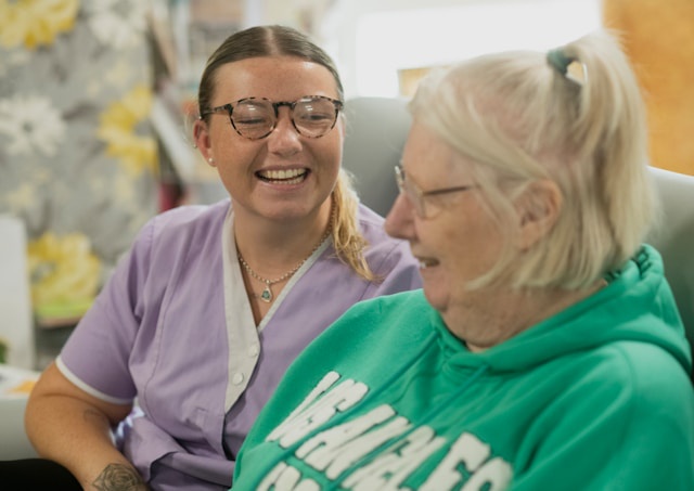 nurse with elderly woman laughing