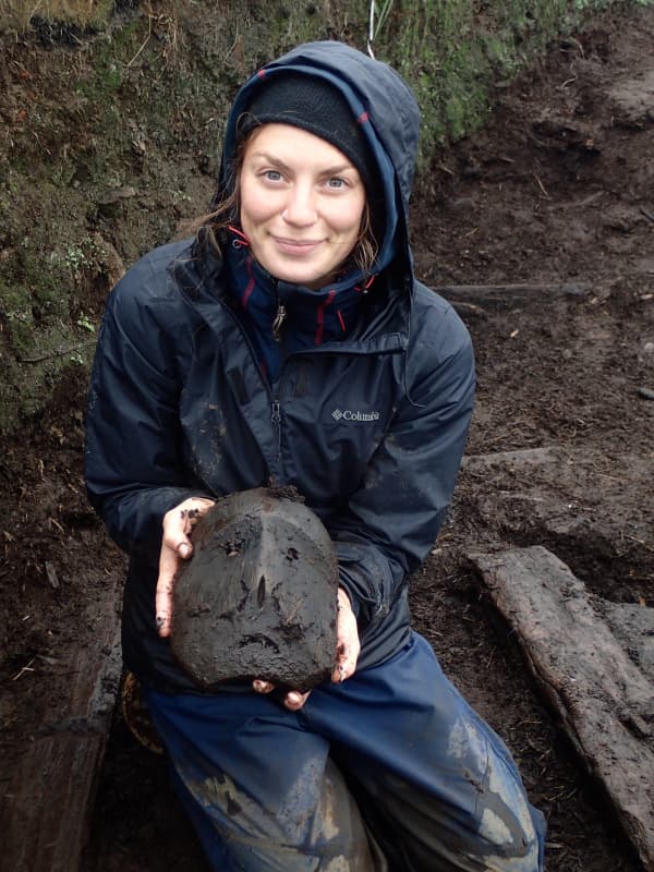 Student showing seal mask from Alaska excavations