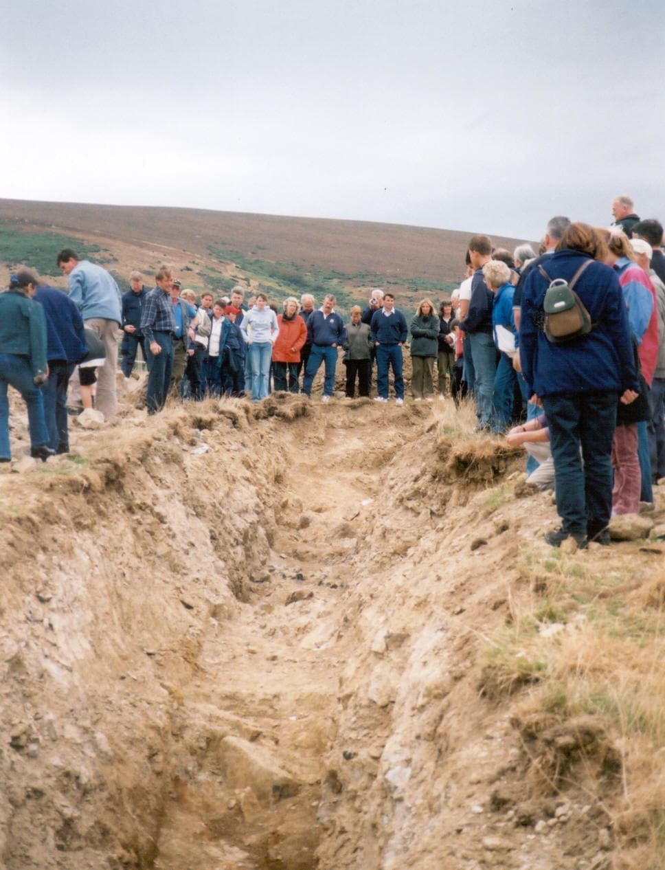 Members of the public viewing the trench excavated through part of the Rhynie chert-bearing sequence at Rhynie.