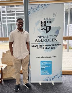 WBP student standing next to UoA poster