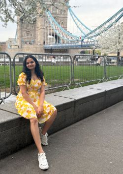Student sitting on wall by London Bridge
