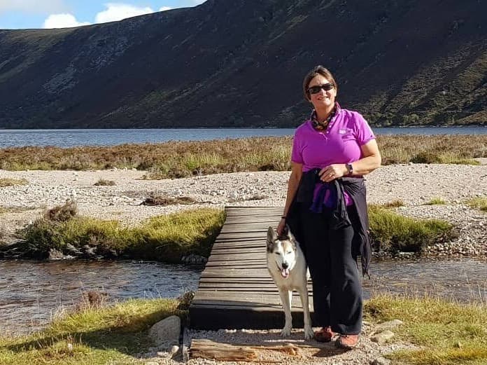 woman with dog by loch