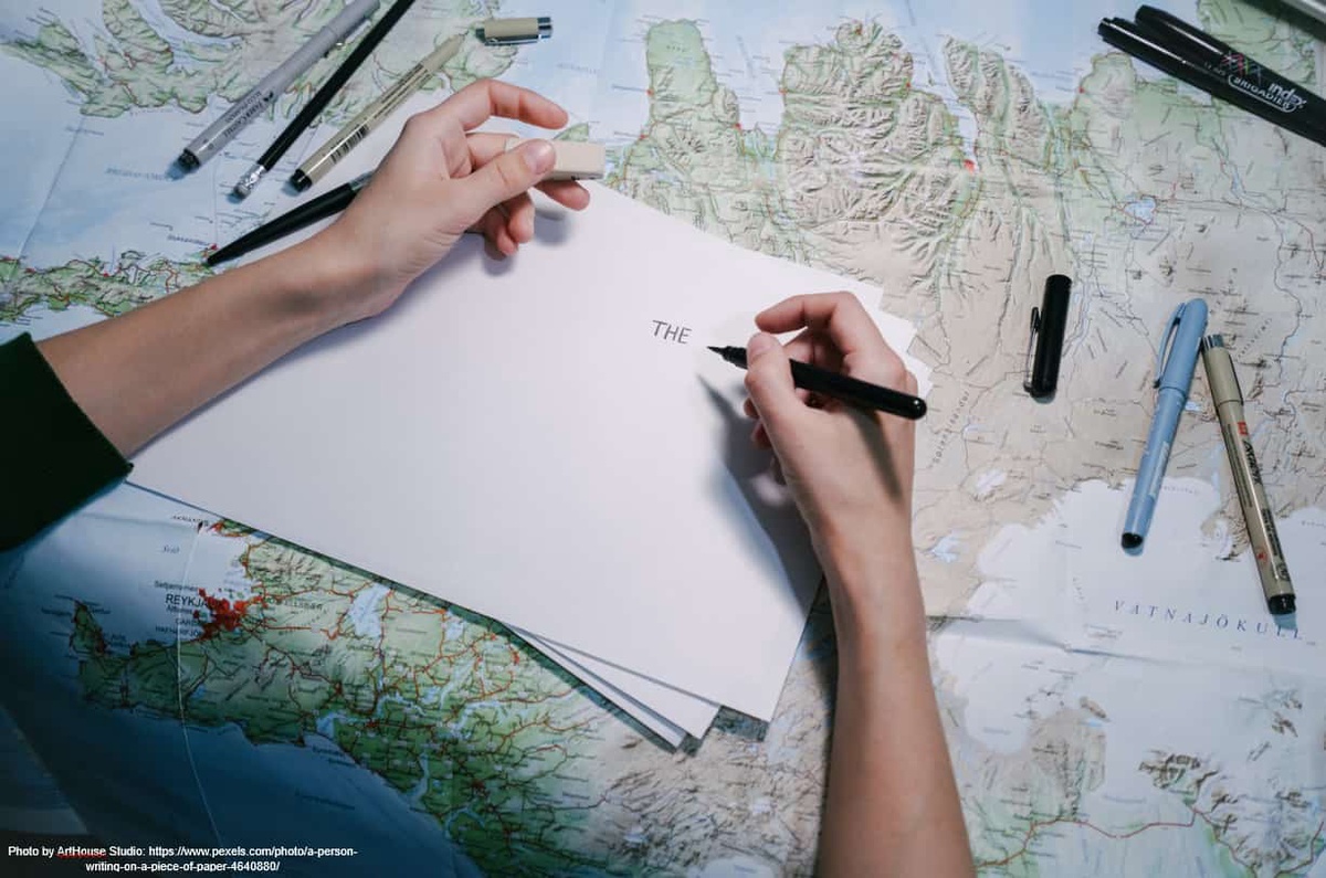 A piece of paper and pen on top of a map of the world