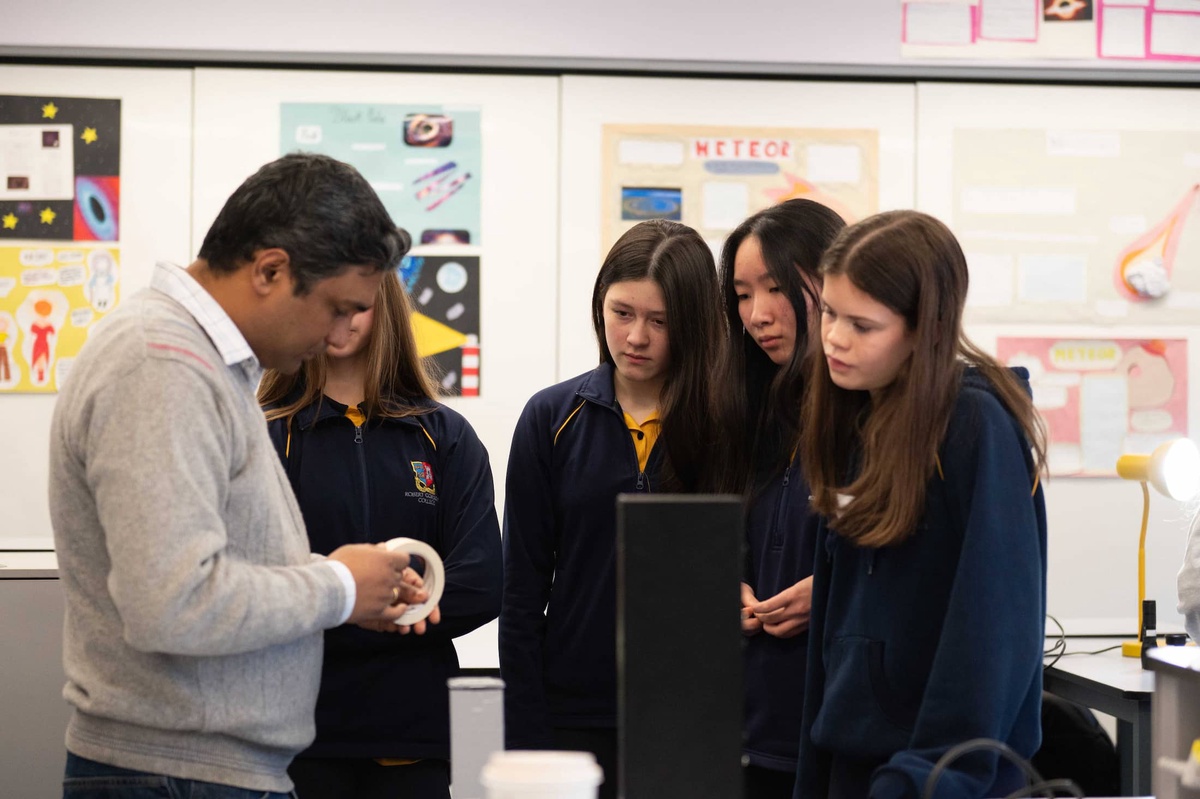 female school pupils being shown something in class