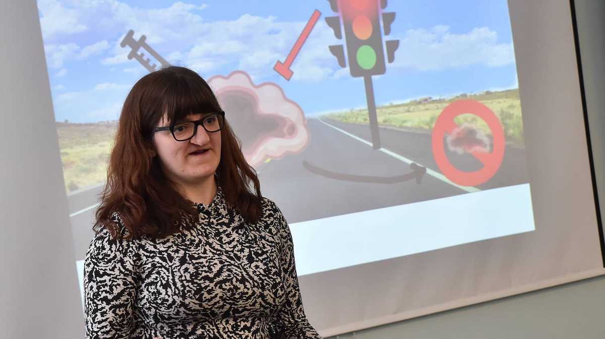 dark haired woman in front of screen