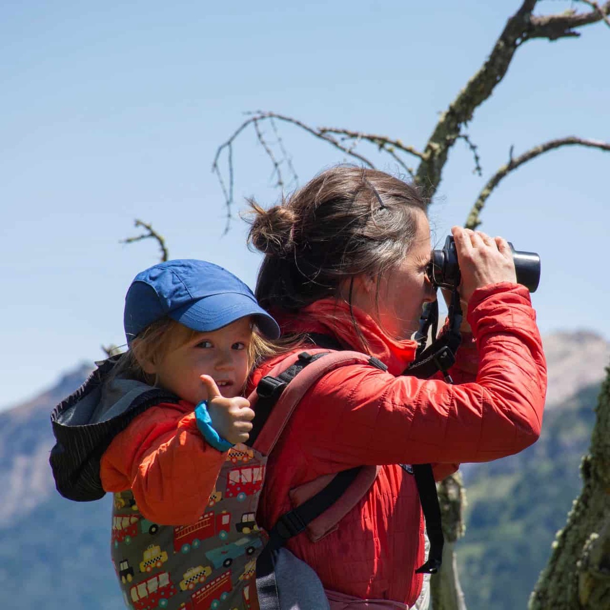 woman in mountains looking through binoculars