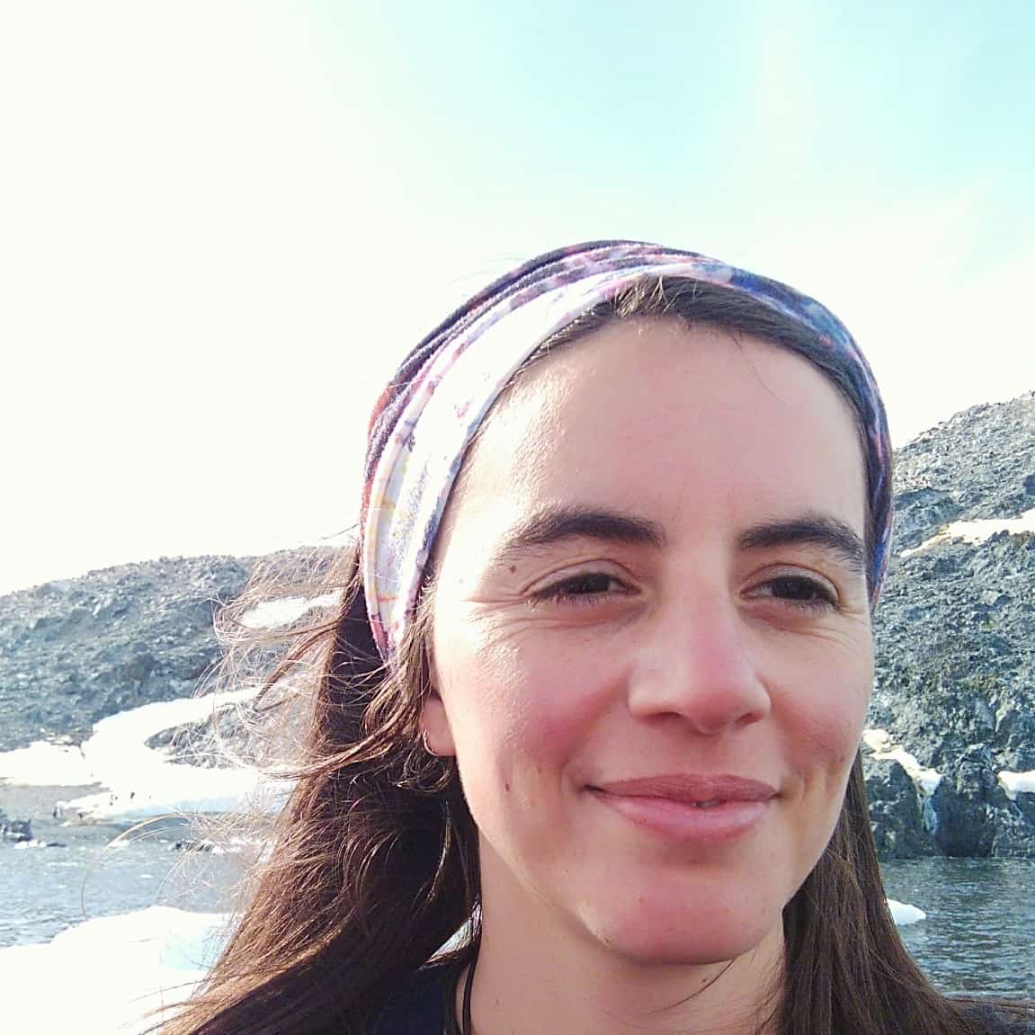 smiling woman next to mountain lake
