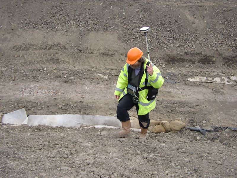 man in mud with metal detector