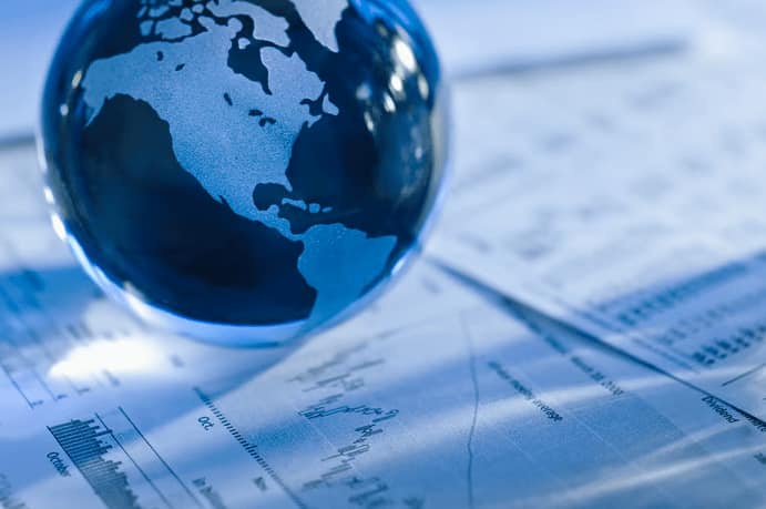 A globe sits on top of a financial report