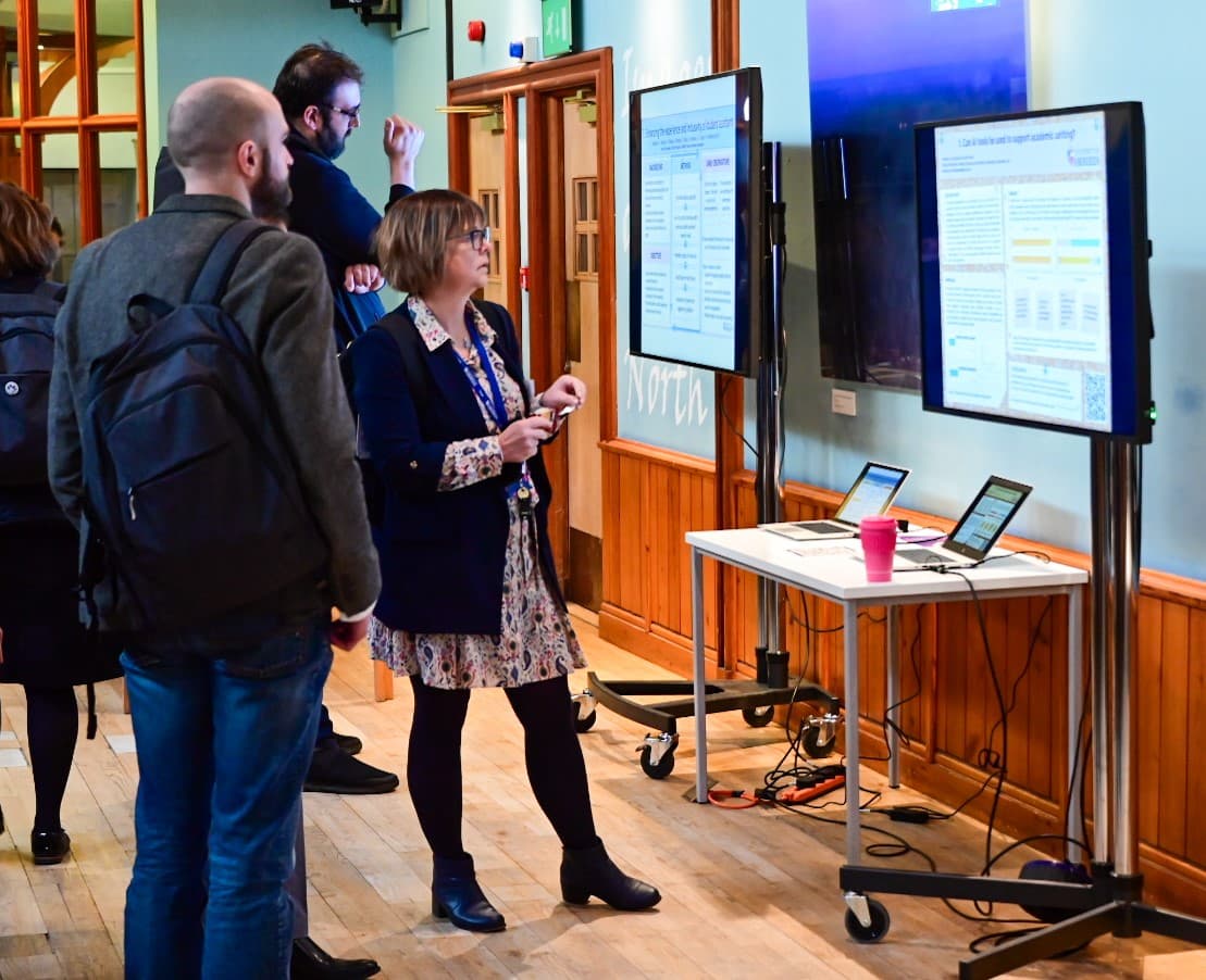 Symposium delegates viewing posters on screens