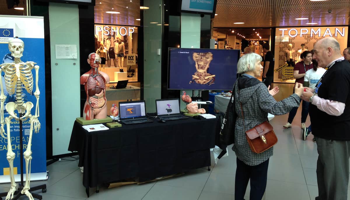 people talking in front of anatomy exhibit