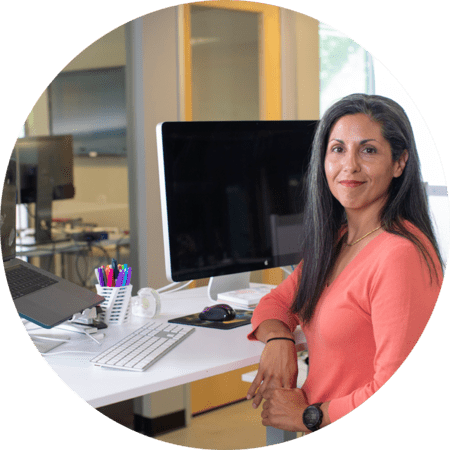 Woman with brown hair standing in front of computer