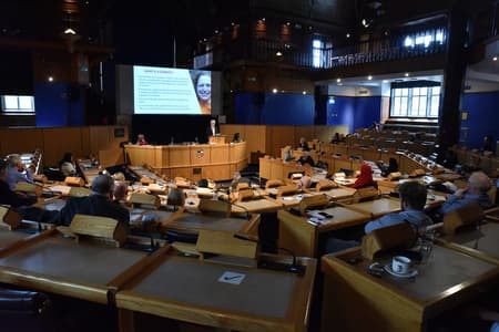 Photo of a person doing a presentation to a lecture room full of people