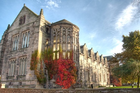 A stone building covered in red ivy