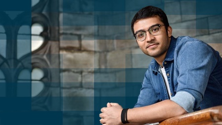 male student sitting in old-style stone building