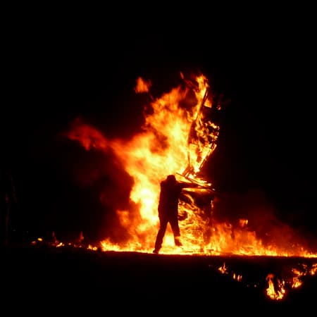 person silhouetted by fire