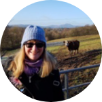Woman with blonde hair wearing blue hat and sunglasses