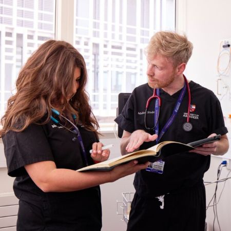 Two medical students looking at a book