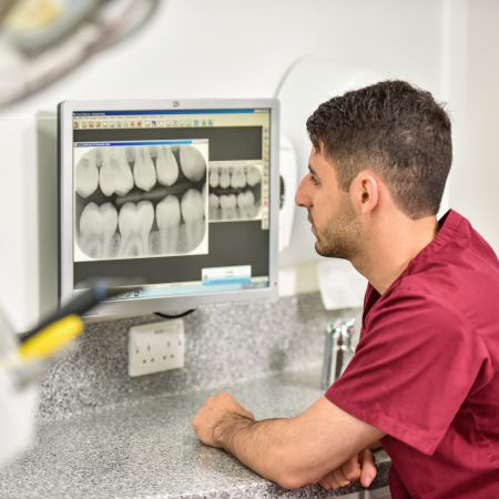 A dental student looking at teeth on a screen
