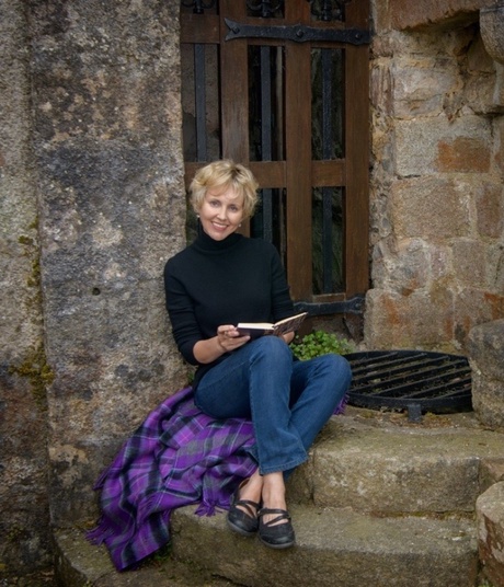 Kimberlie sitting in front of a castle with a book in her hands