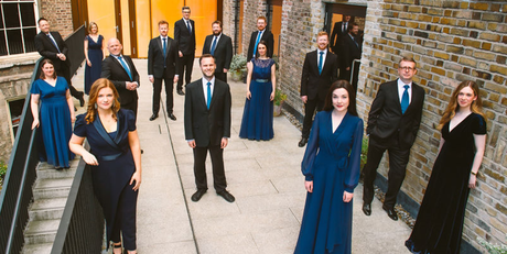 Members of the Chamber Choir in formal clothing, in front of a brick building