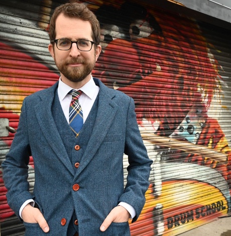 Profile of Professor Matt Brennan, standing in front of graffiti.