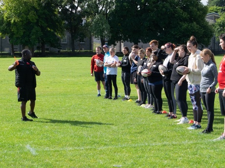 The students lined up on the playing fields taking instruction from their coach