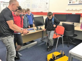 Pupils watching a robot in the engineering lab