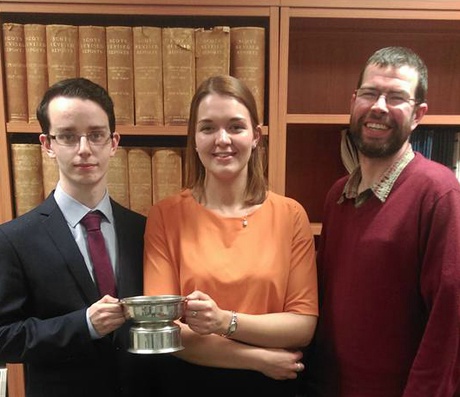 Euan (left) and Jennifer are pictured with the winners' trophy alongside University law lecturer Malcolm Combe