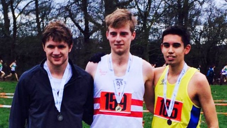 Michael Ferguson (centre) celebrates winning his cross country race just hours after his engineering exam