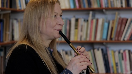 Woman playing tin whistle in library