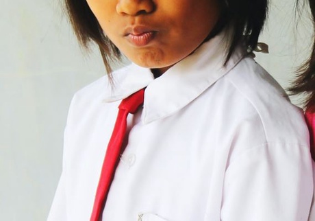 Cropped image of a female school pupil in a white shirt and tie