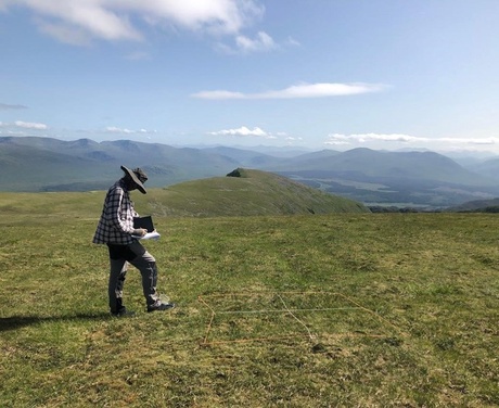 Zac recording vegetation height, GPS coordinates and identifying mosses at the top of Creag Meagaidh with a beautiful view of the mountain ranges.