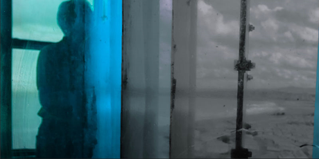 Abstract image of a person silhouetted behind blue and grey glas