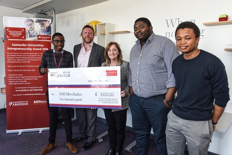 Dr Rotimi Alabi founder of RAB Microfluidics, Dr Zachary Hickman, Knowledge Exchange and Commercialisation in Research & Innovation (competition coordinator at UoA), Dr Liz Rattray (presenting the cheque), Director of Research & Innovation, Roy Bitrus and Surakat Kudehinbu, RAB Microfluidics team members